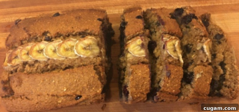 Overhead view of a delicious loaf of quick bread, beautifully adorned with a neat row of sliced bananas down its center.