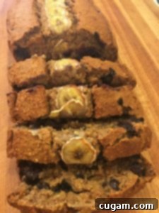 Banana bread on a cutting board, half of it sliced.