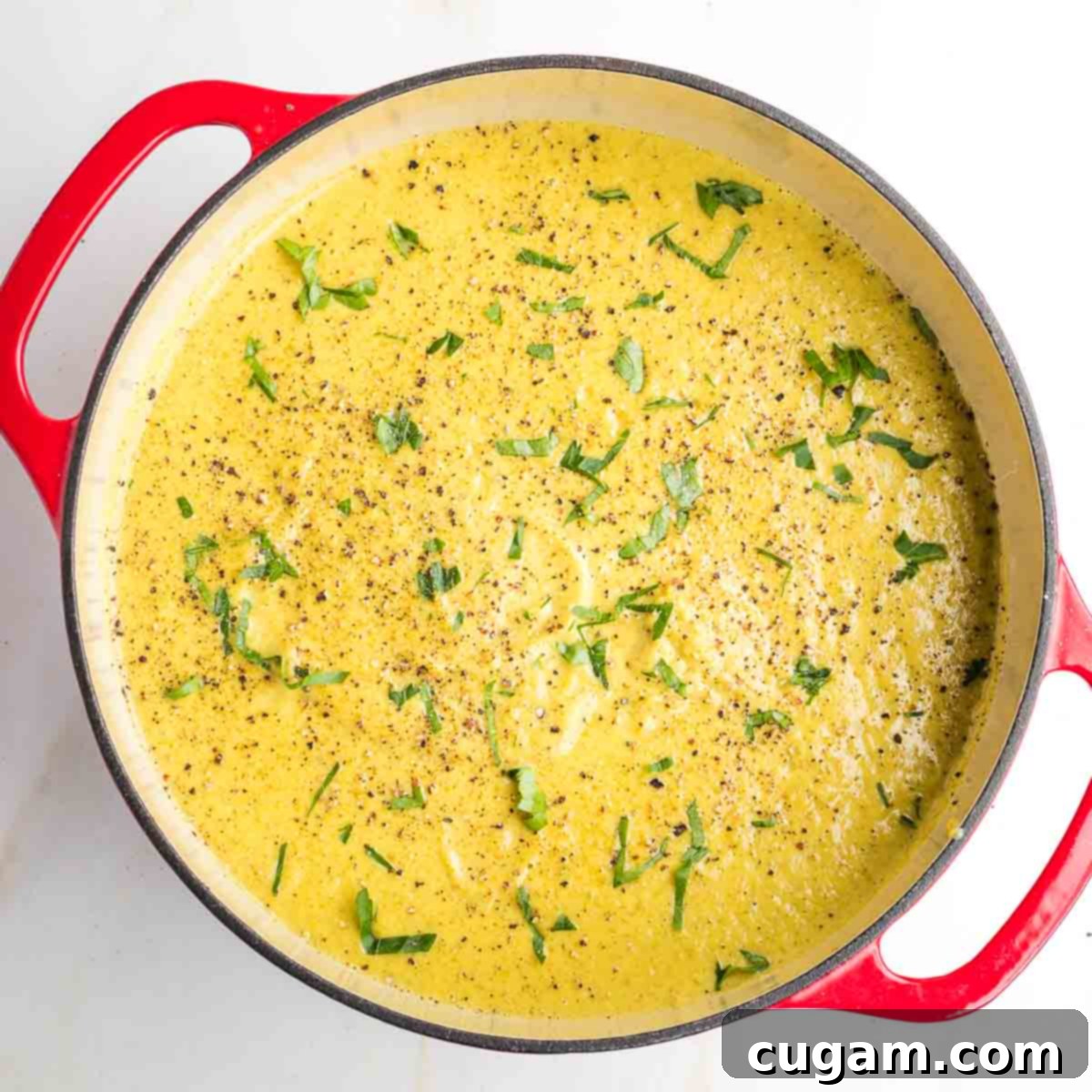 A spoon dipping into the finished creamy vegan broccoli soup, ready for tasting and seasoning.