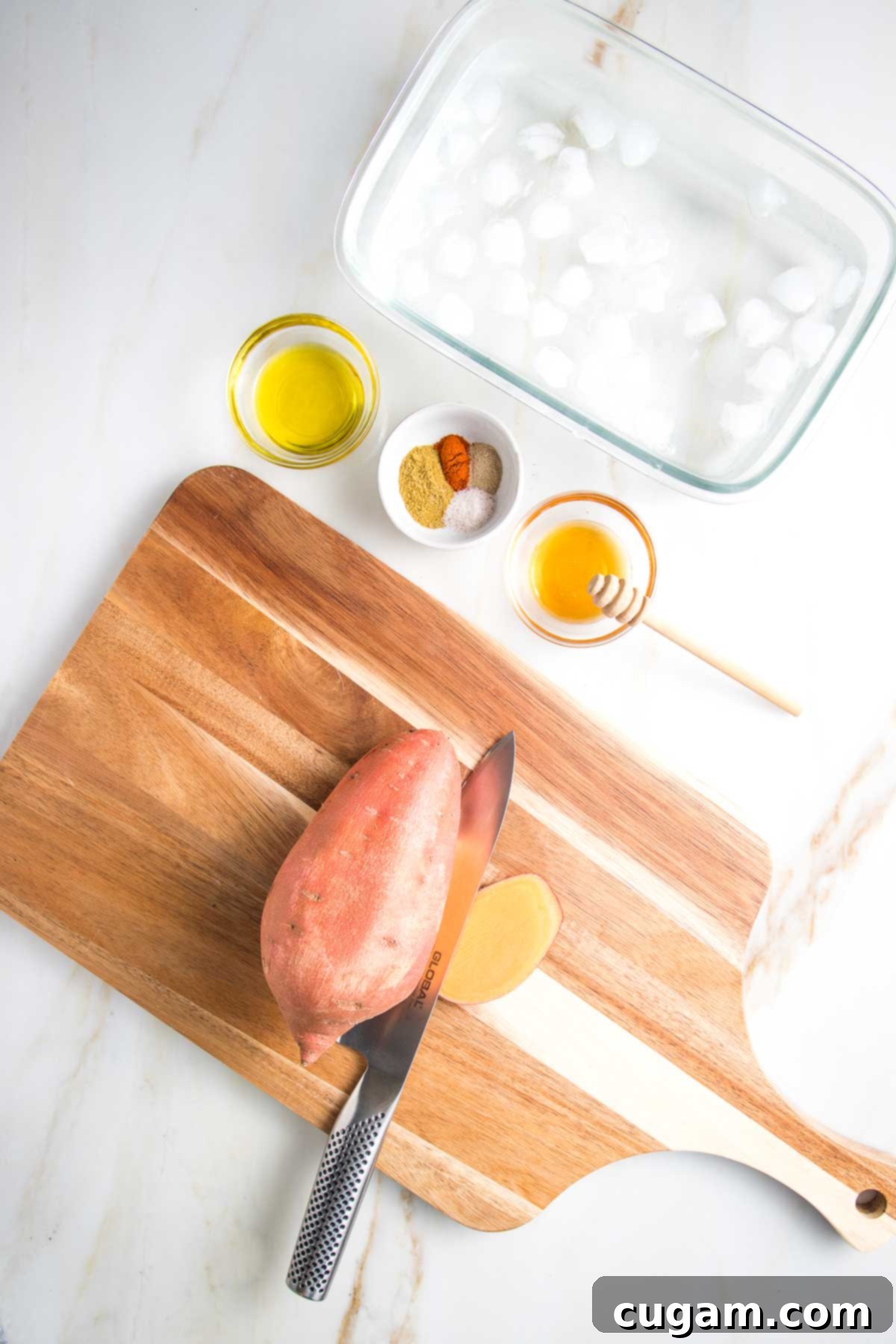 Cutting board with a sweet potato with a sliver cut off one lengthwise side.