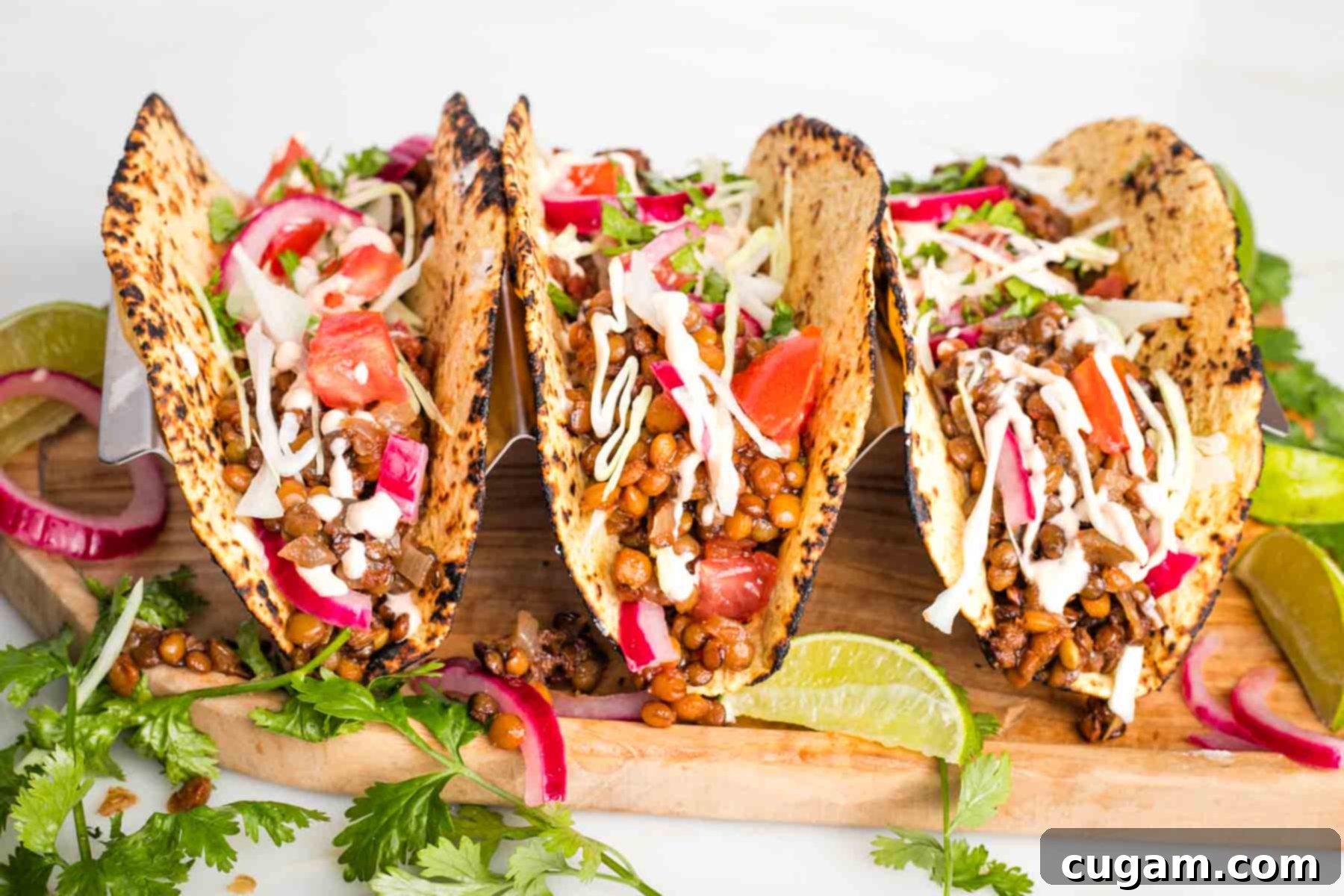 A colorful spread of fresh taco toppings including avocado slices, lime wedges, fresh cilantro, red cabbage, cherry tomatoes, and various salsas.