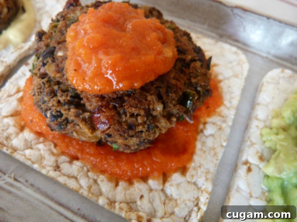 Red pepper sauce underneath and on top of a mini black bean veggie burger.