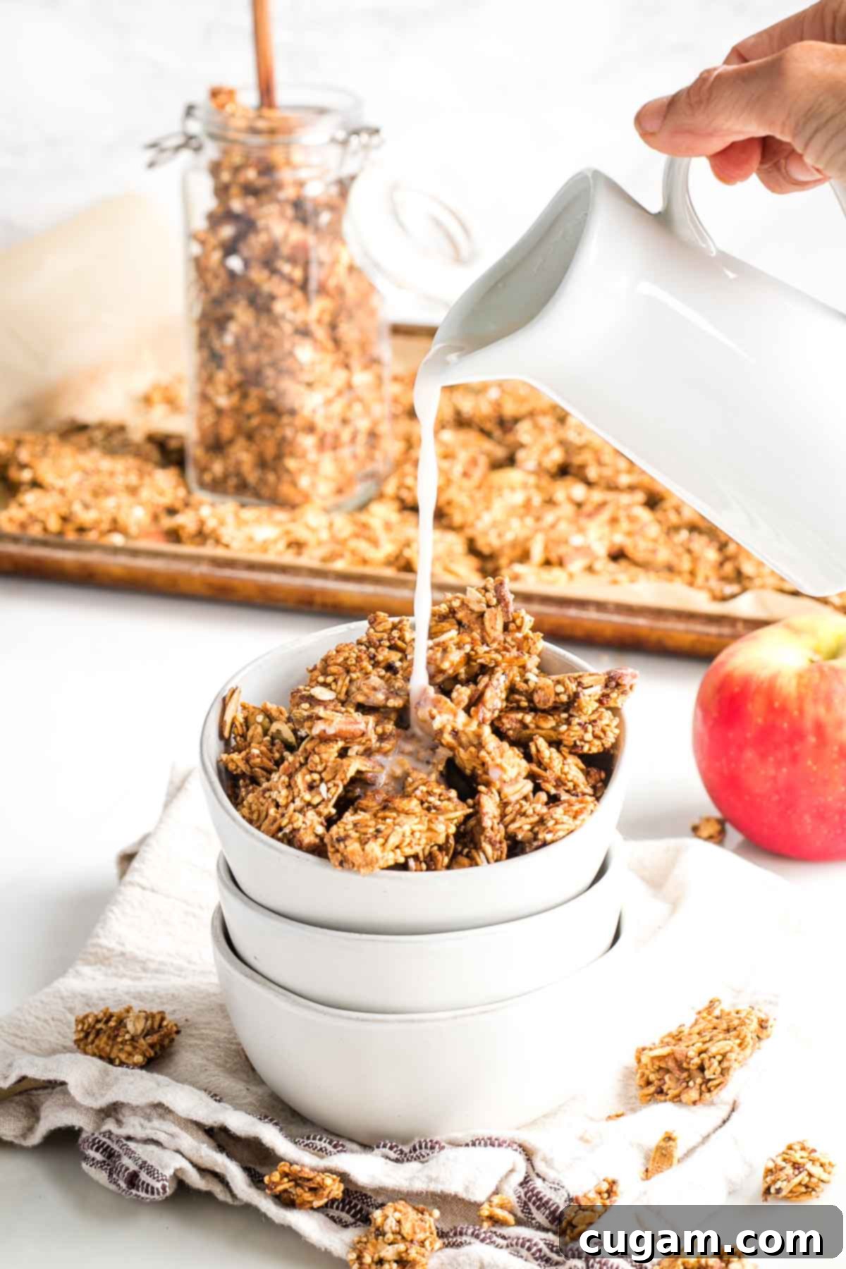 Pouring milk over granola clusters in a bowl, showcasing its crunchy texture.