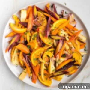 Plate filled with colorful roasted carrots and parsnips with oranges.