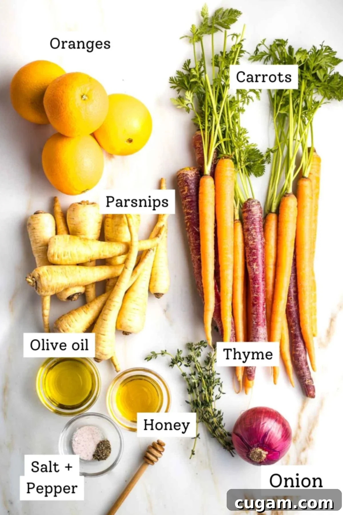 Assortment of fresh ingredients for honey roasted carrots and parsnips recipe, including root vegetables, oranges, and herbs.