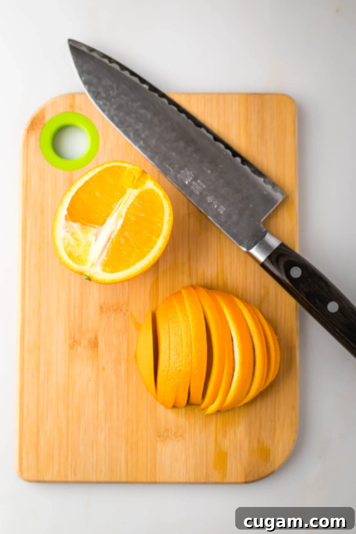 An orange halved, with one side sliced into thin half moons.