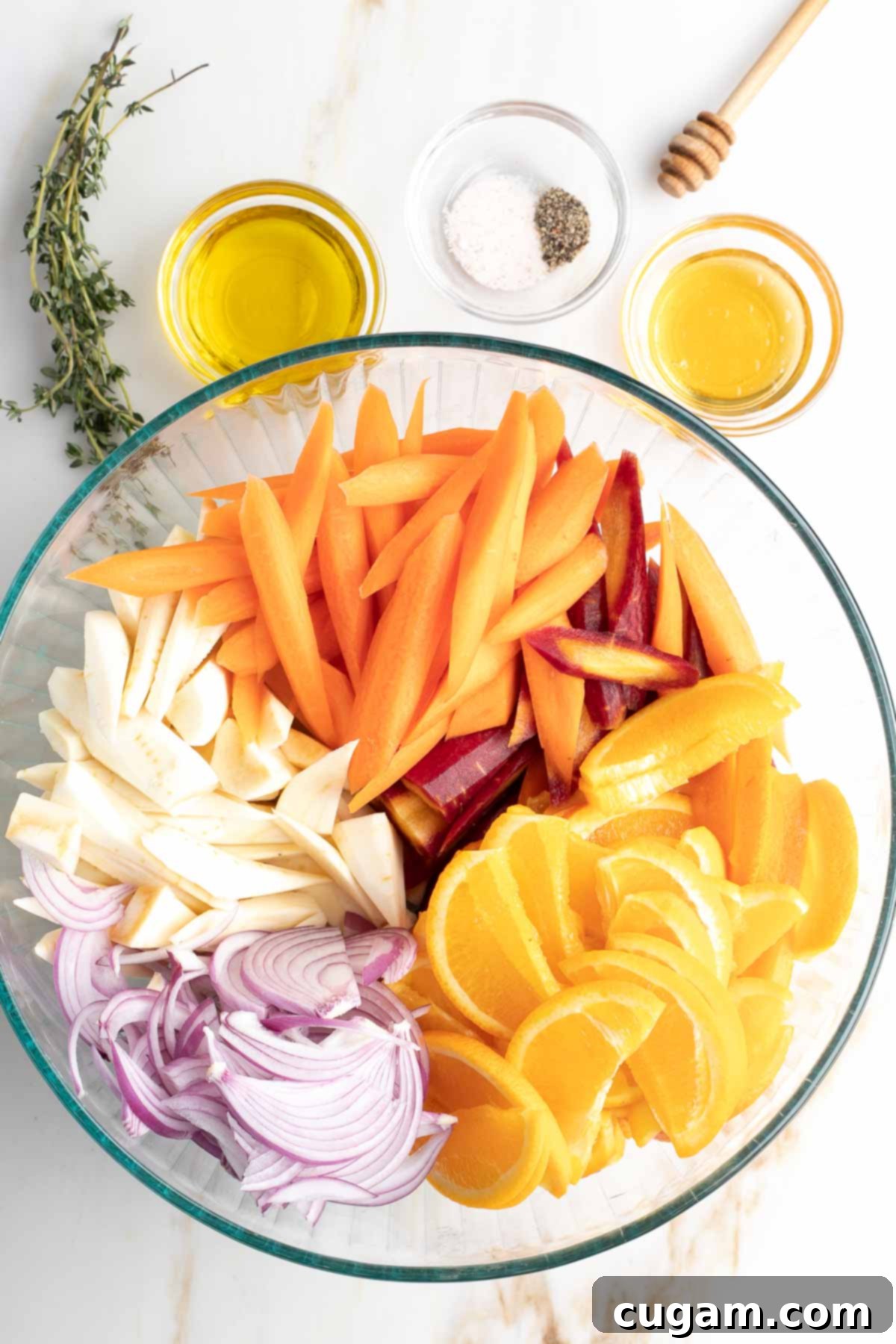 Bowl of colorful sliced veggies, plus olive oil, honey, spices and fresh thyme.