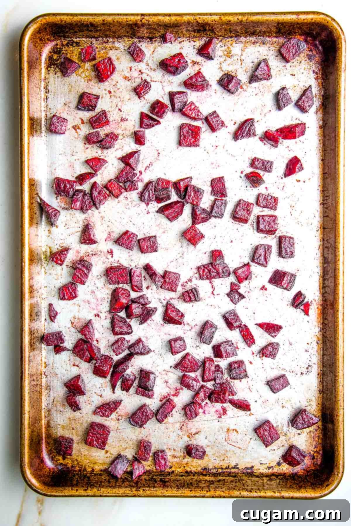 Roasted diced beetroot on a large baking tray.