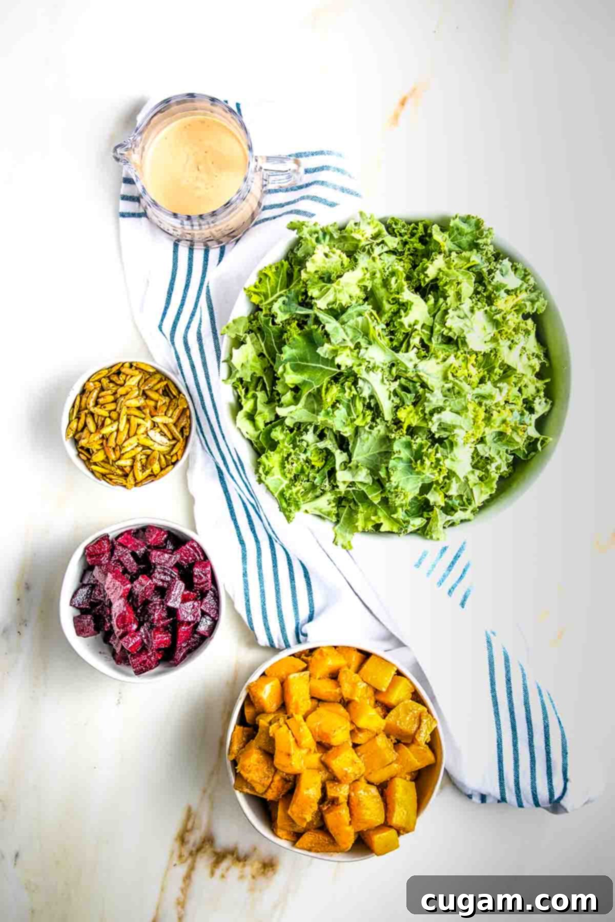 Bowls with massaged kale, roasted squash, roasted beets, toasted pepitas and a creamy dressing.