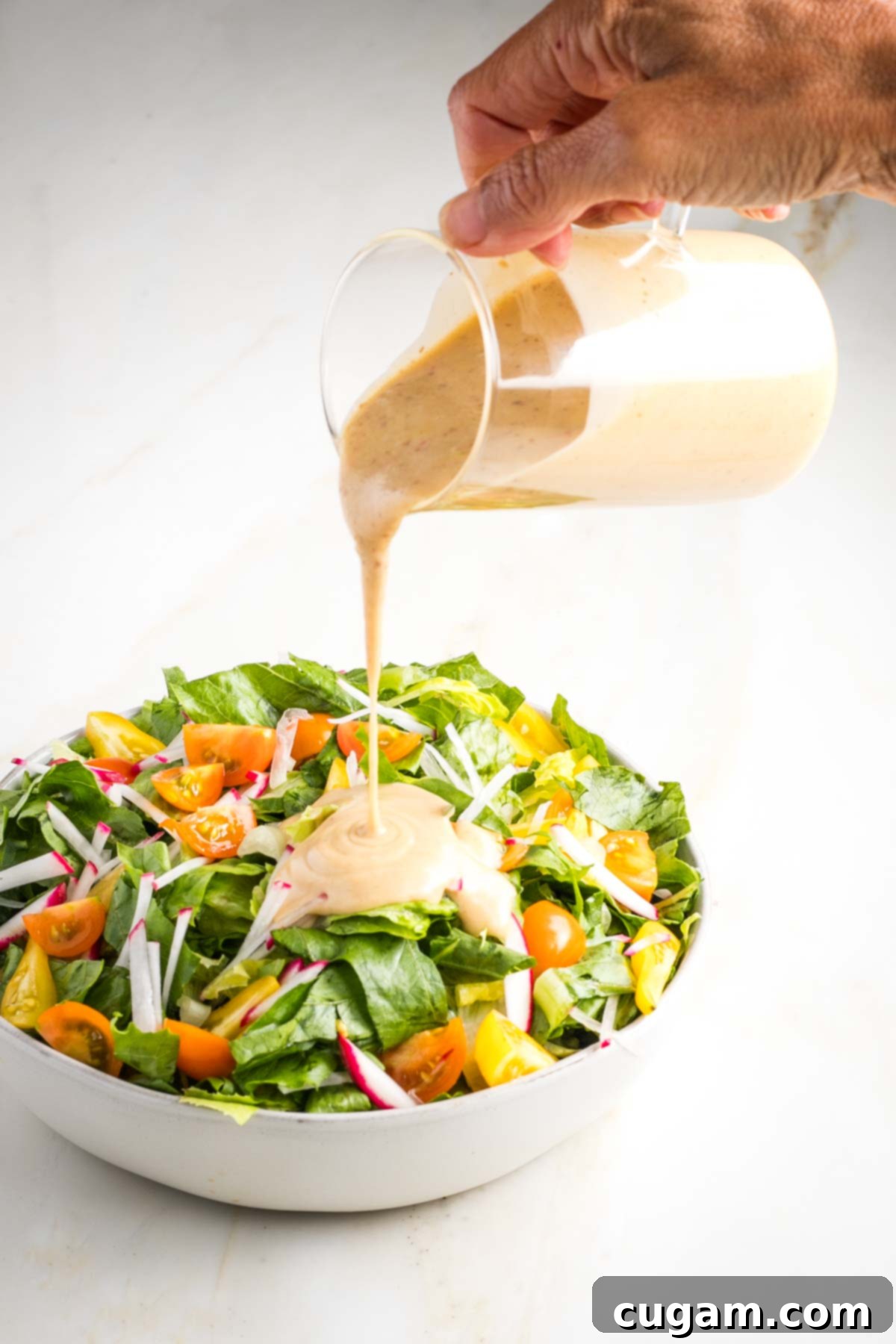 Creamy garlic dressing drizzled over a fresh green salad.