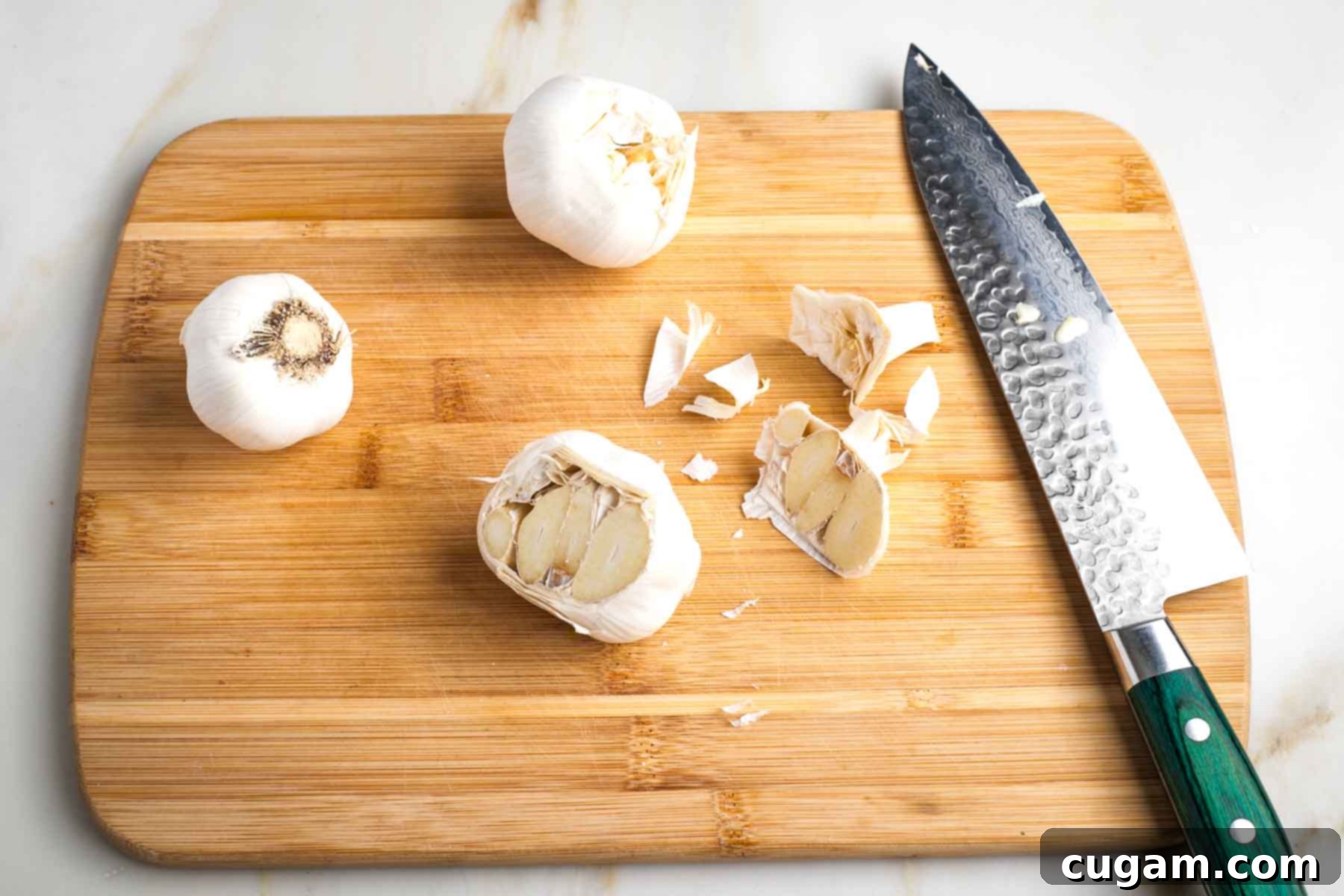 Whole head of garlic trimmed, exposing flesh of cloves.