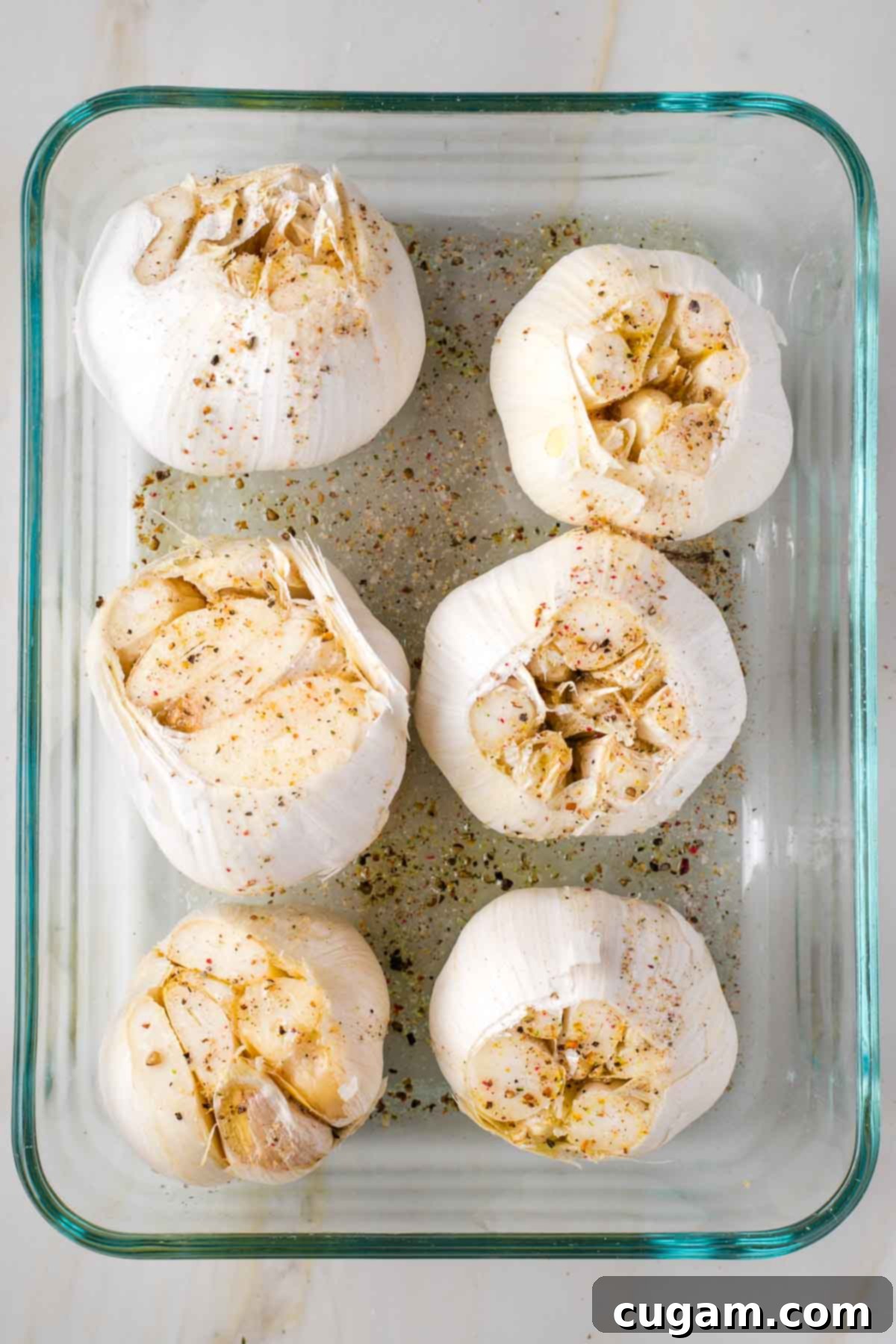 6 whole heads of garlic in a baking dish, drizzled with oil and sprinkled with salt and pepper.