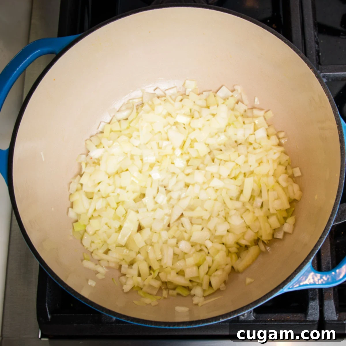 Diced onions inside a dutch oven, cooking.