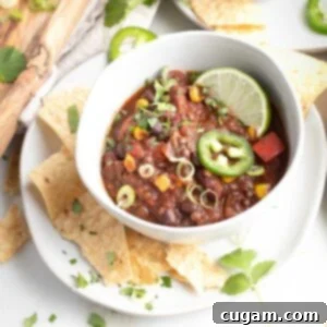 Quick and Easy Vegan Lentil Chili 12 Vegan Chili with lentils, red peppers and corn, garnished with lime, cilantro and jalapeno.