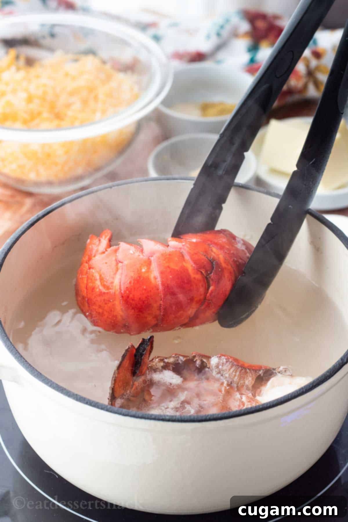 Black tongs carefully removing a vibrant red lobster tail from a white enamel pot of hot, steamy water, creating a gentle steam.