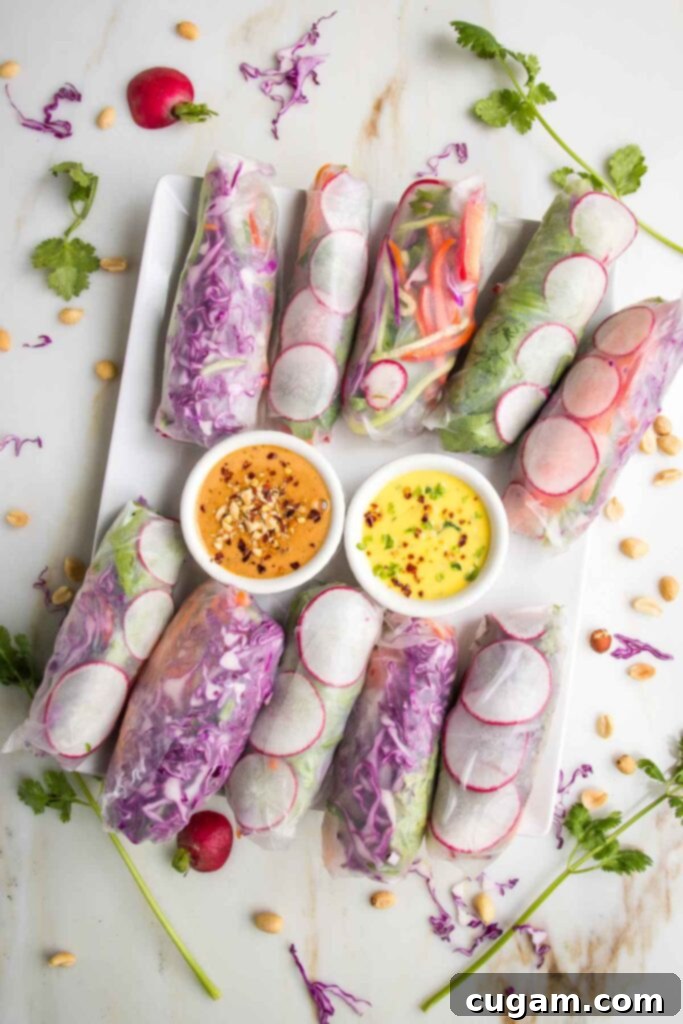 Crisp Veggie Spring Rolls with Creamy Peanut Sauce 16 Large rectangular platter filled with colorful spring rolls and two dipping sauces. Yellow mango and orange peanut butter sauce.