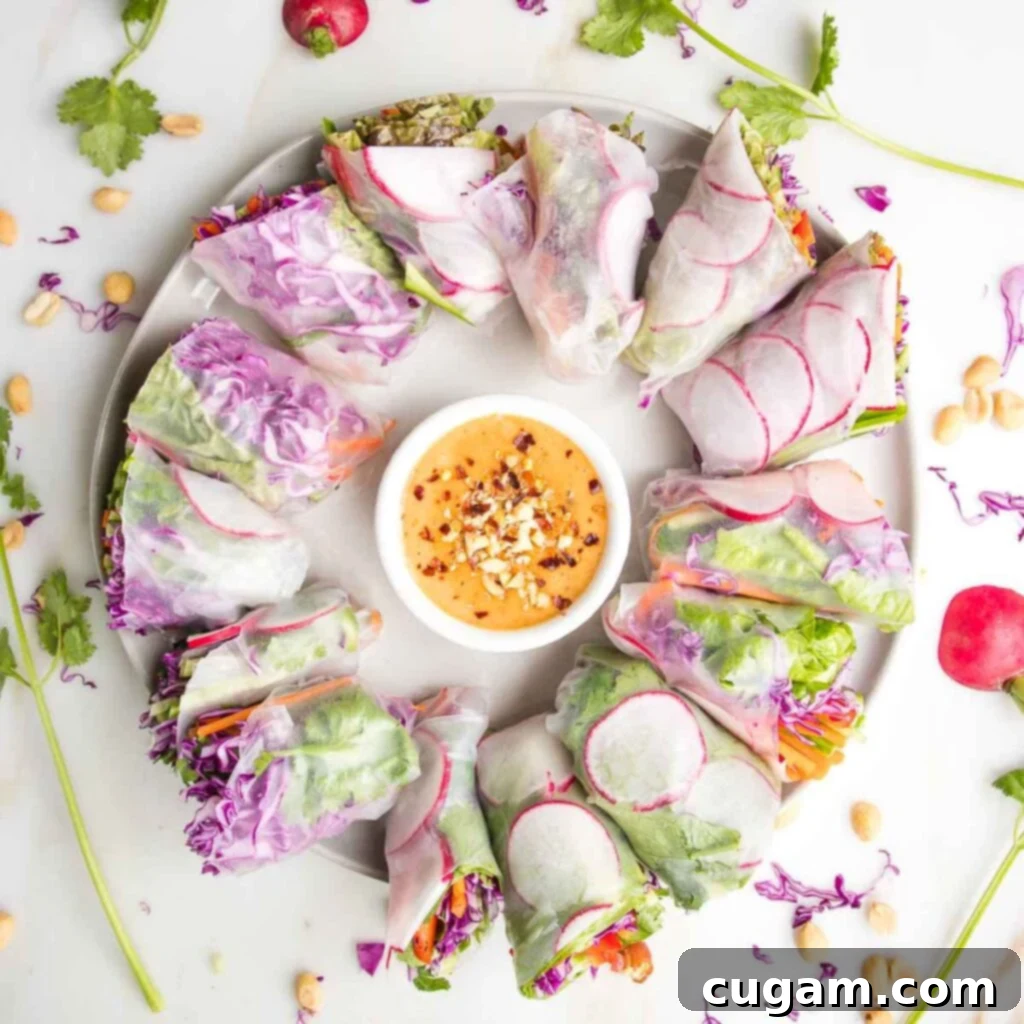 Crisp Veggie Spring Rolls with Creamy Peanut Sauce 17 Round platter with a small bowl peanut dipping sauce in the center, surrounded by fresh spring rolls.