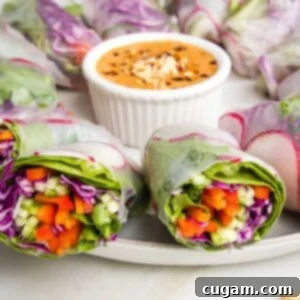 Crisp Veggie Spring Rolls with Creamy Peanut Sauce 21 Fresh spring rolls cut in half with colorful julienned veggies shown and a small dish of peanut sauce. veggies