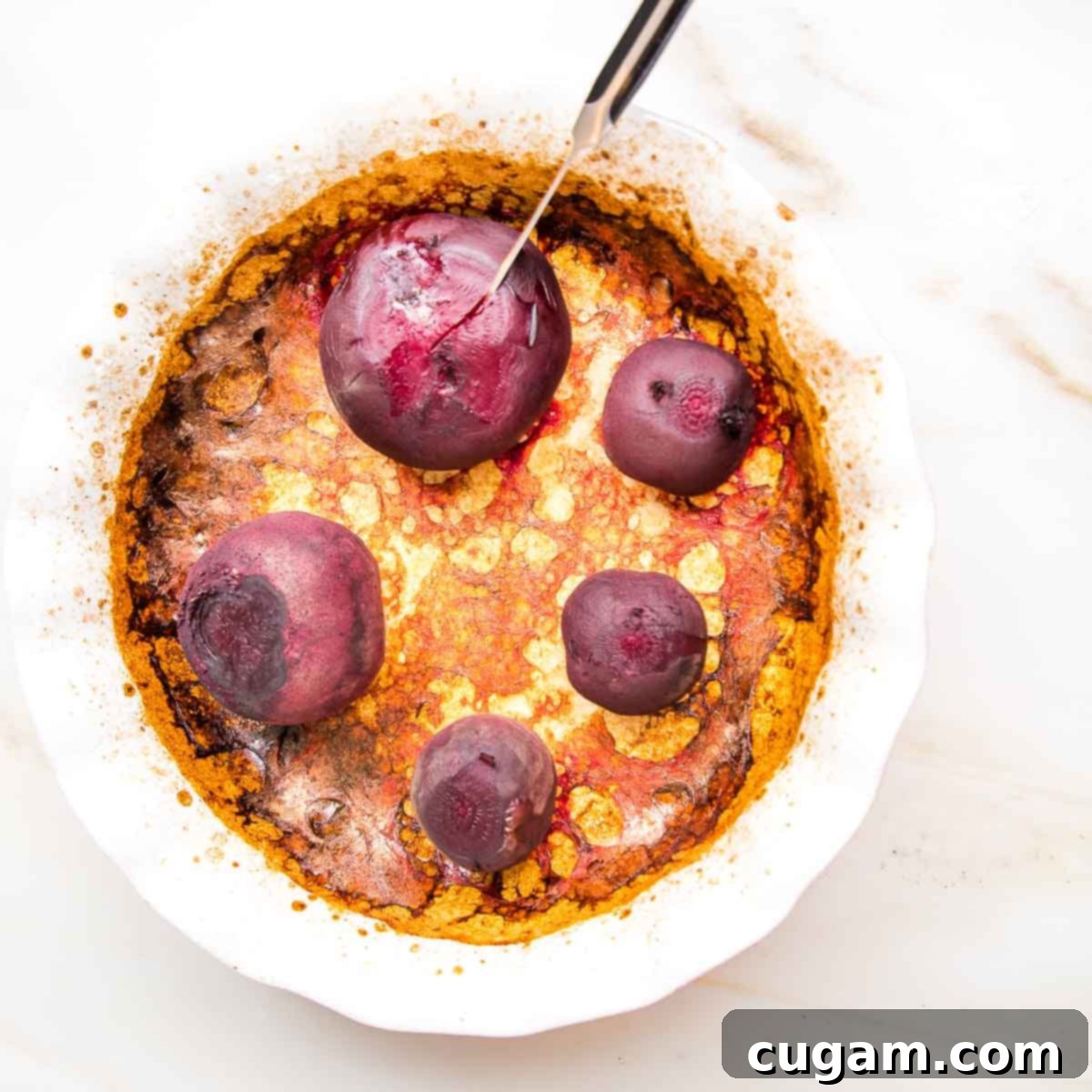 Whole red beets, roasted, browned in a pie plate. 