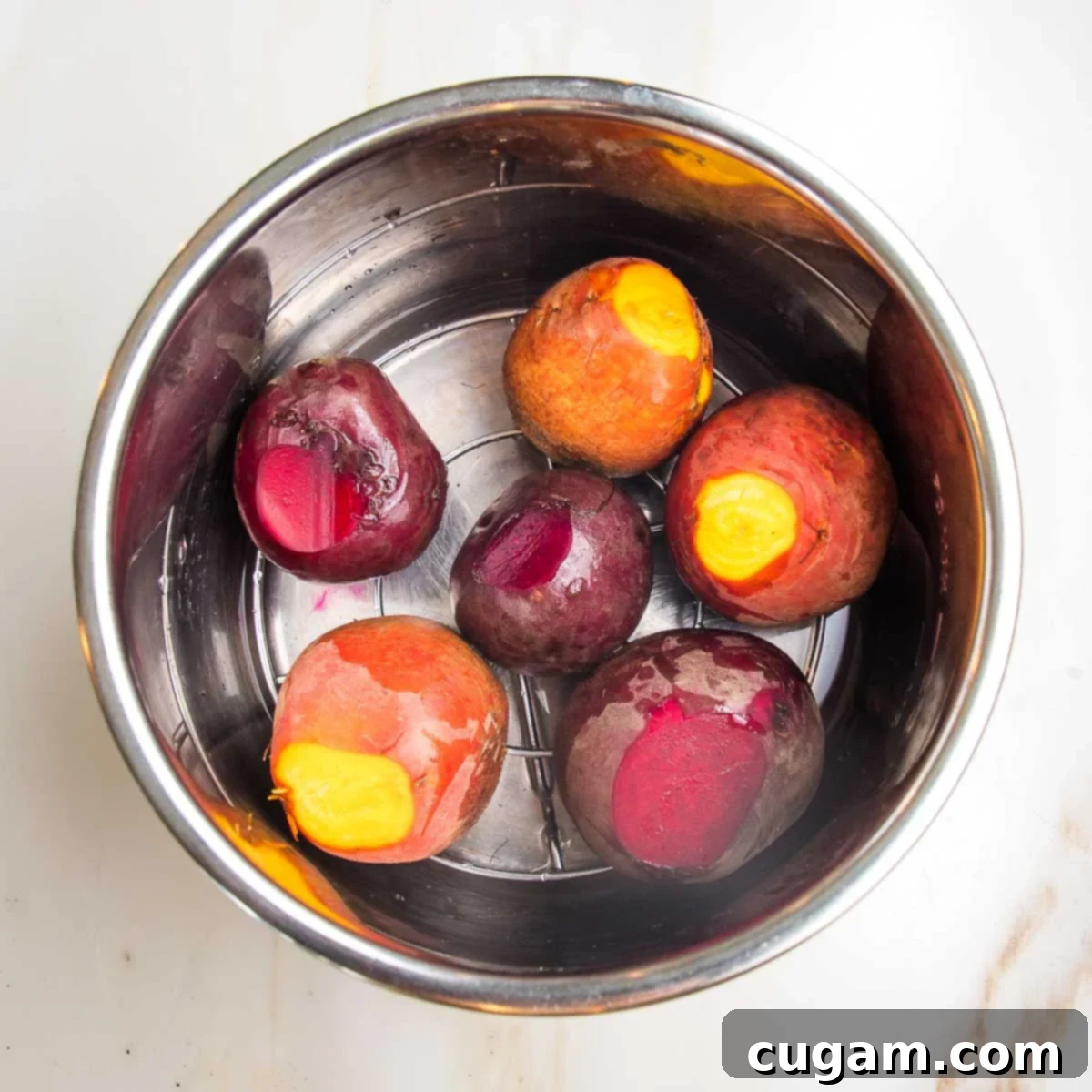 Whole beets, trimmed in an instant pot bowl on a rack with 1" of water.