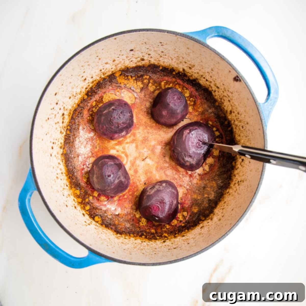 Roasted whole red beets and golden beets in a dutch oven. Tender, moist and ready to be peeled.