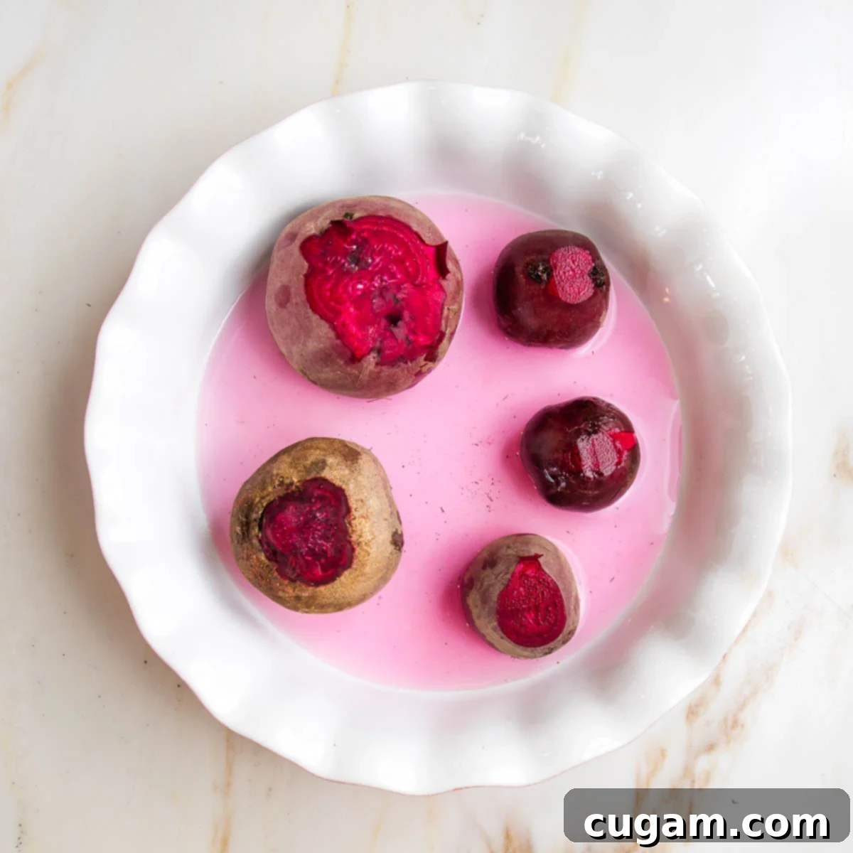 Whole red beets in a pie plate with ¼" water.