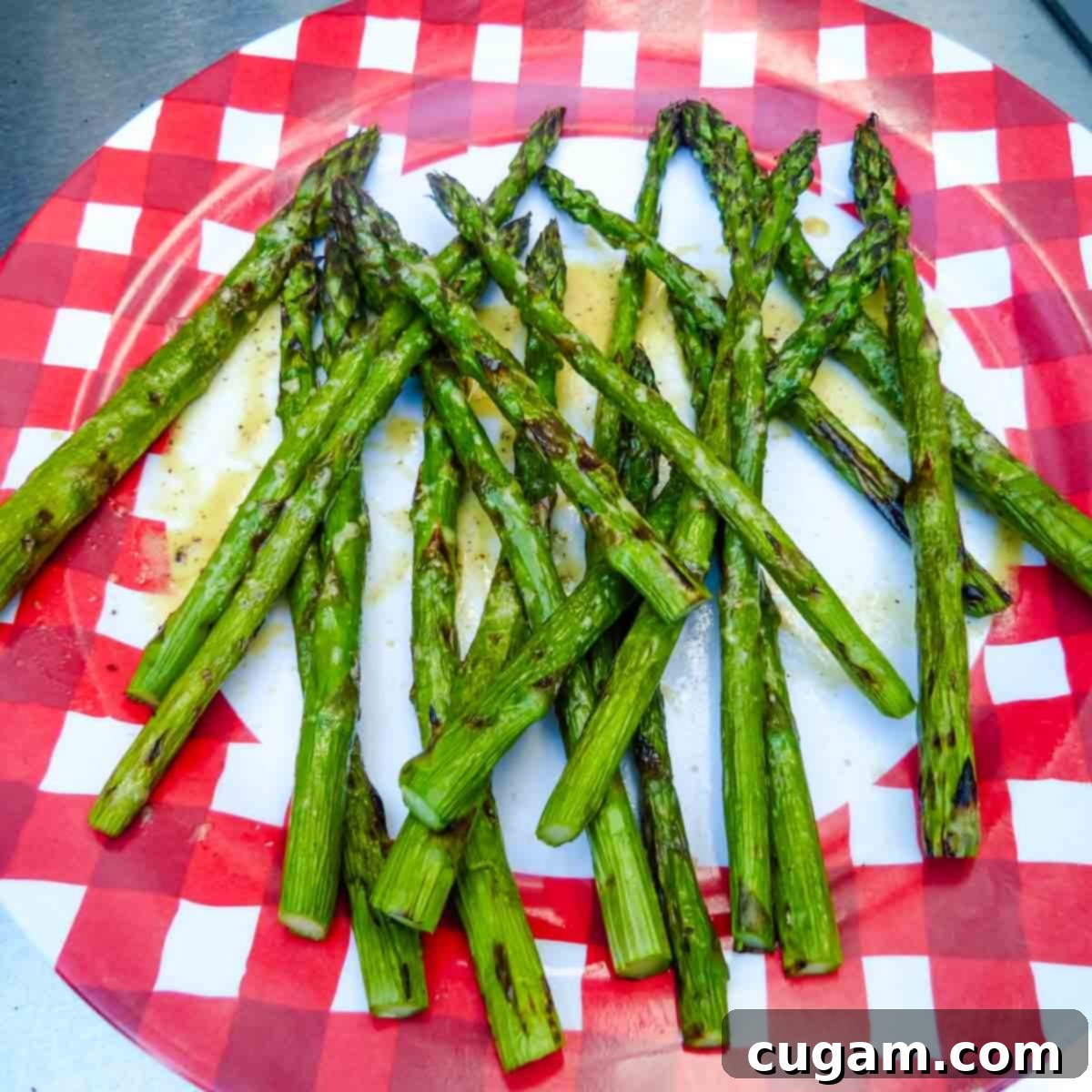 A vibrant platter of grilled asparagus spears, beautifully arranged and generously drizzled with the homemade mustard sauce.
