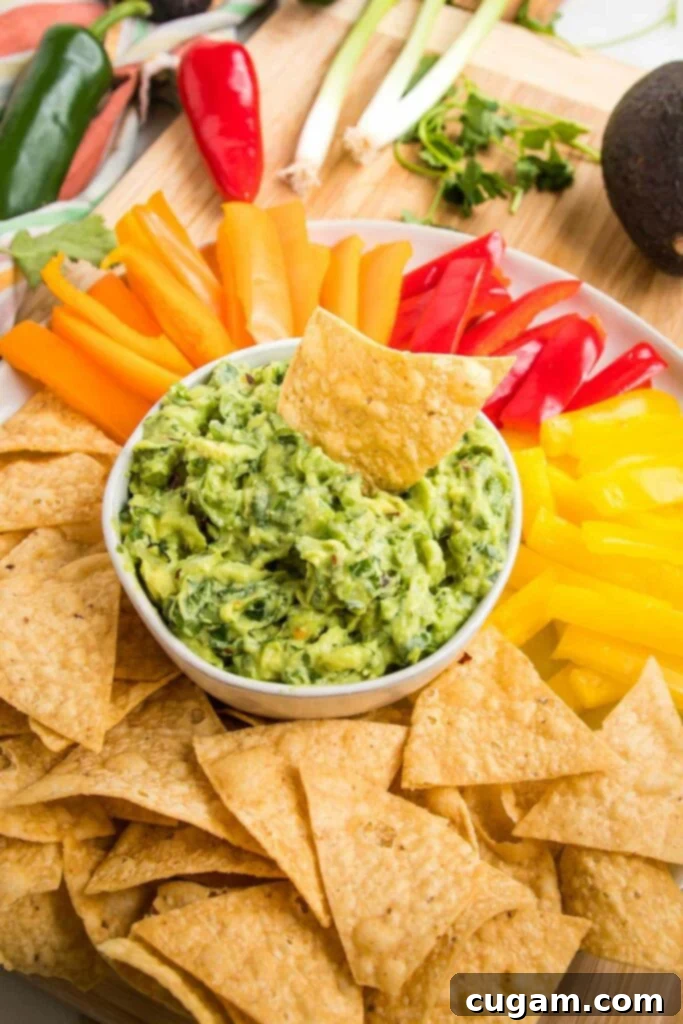 Creamy homemade guacamole in a bowl, surrounded by fresh avocados