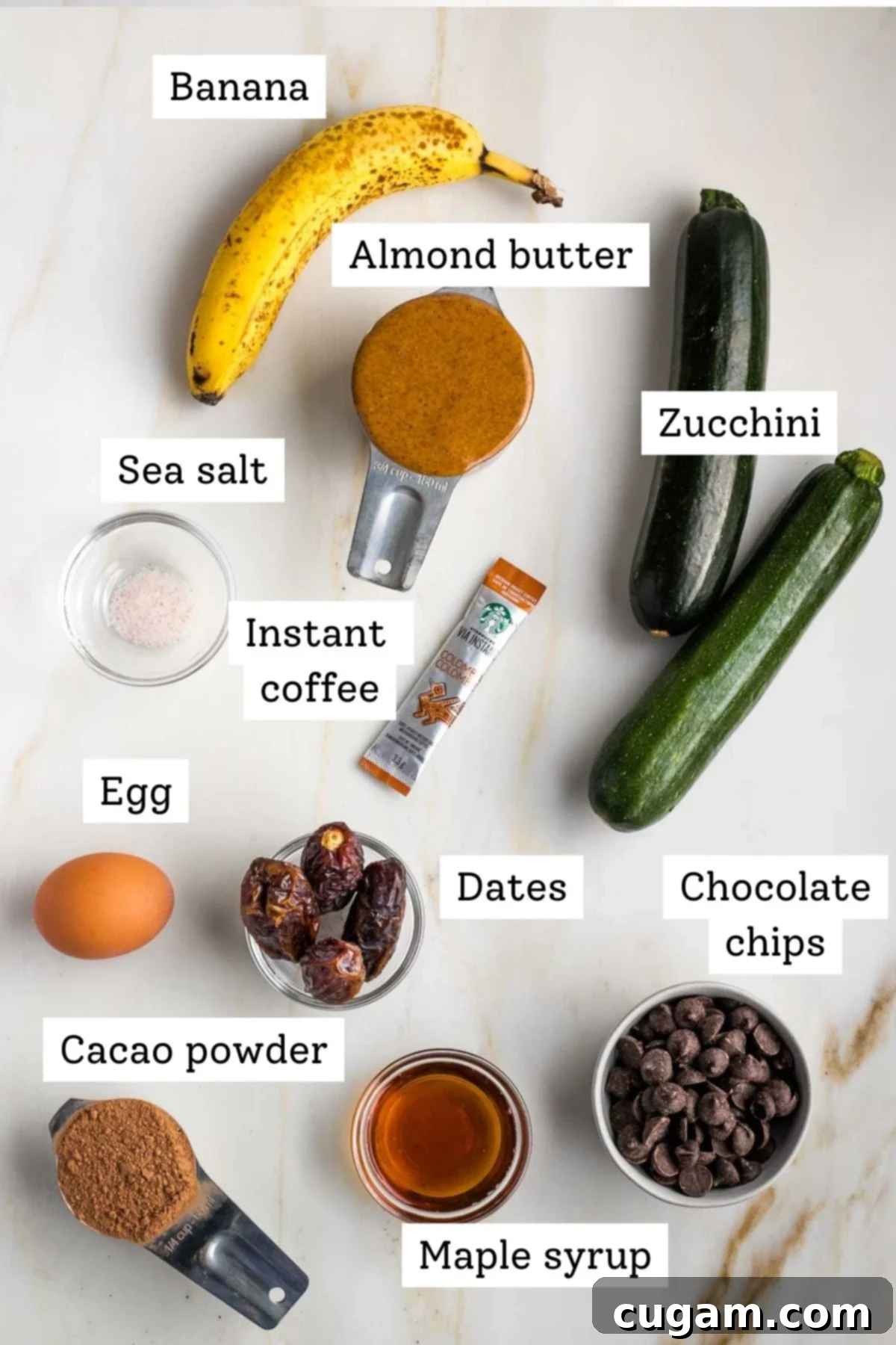 Decadent Double Chocolate Zucchini Muffins 4 Organized ingredients for double chocolate zucchini muffins: banana, almond butter, shredded zucchini, salt, egg, dates, maple syrup, cacao powder, instant coffee, and dark chocolate chips.