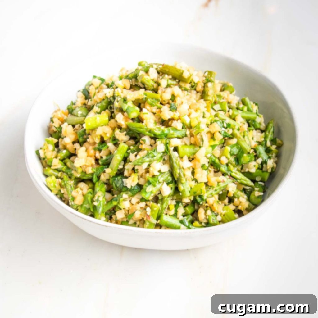 Bowl filled with cauliflower rice and asparagus.