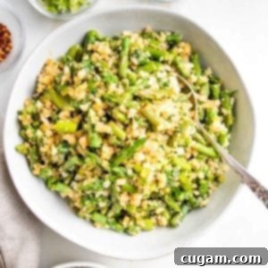 Large white serving bowl filled with Cauliflower rice and asparagus.