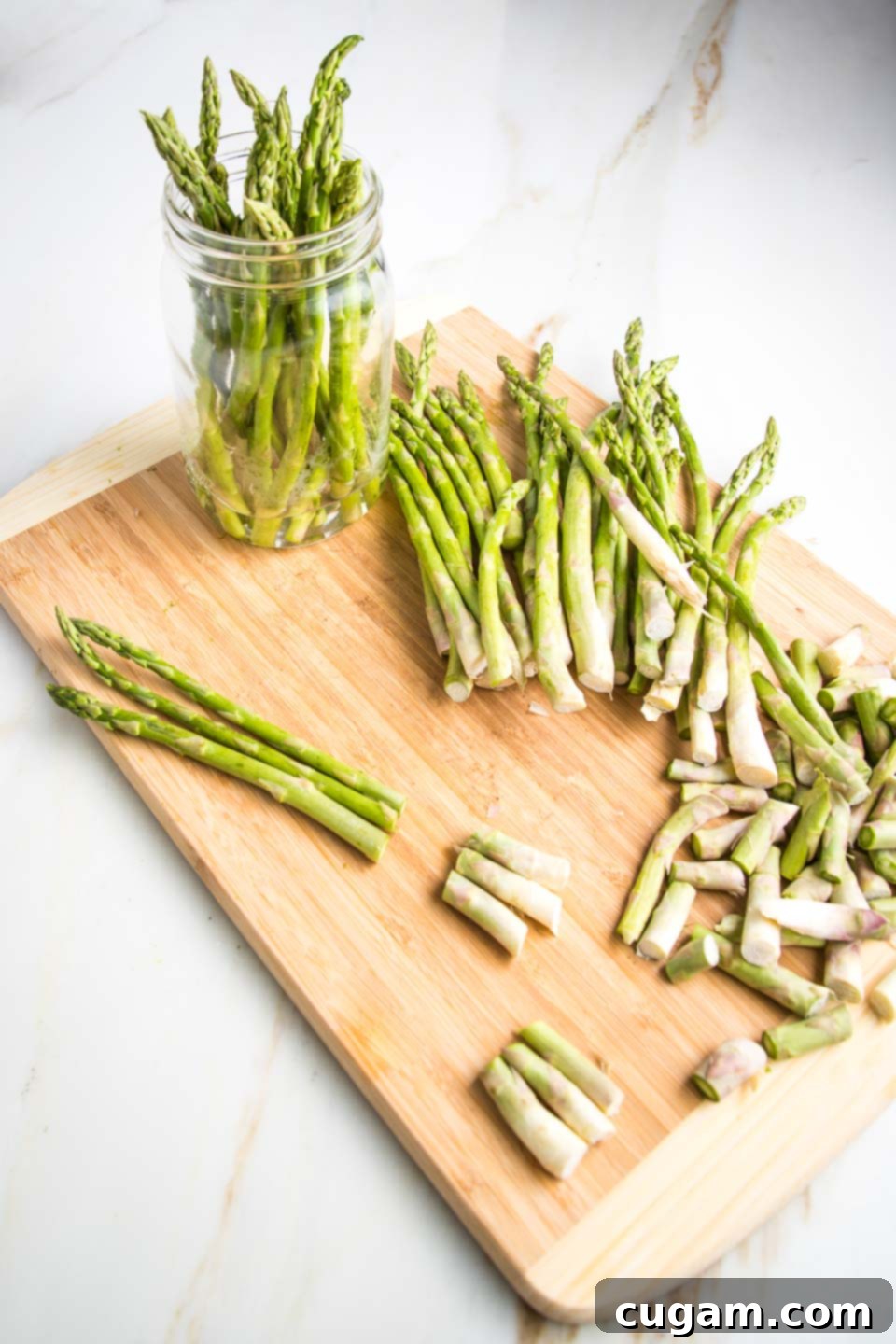 Trimming asparagus to store in a glass jar with water.