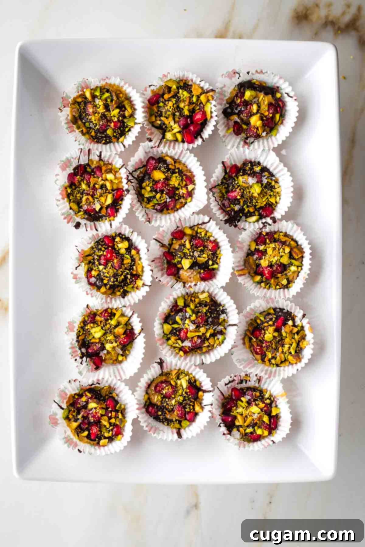 Platter filled with chocolate peanut butter cups with pistachios and pomegranate seeds.