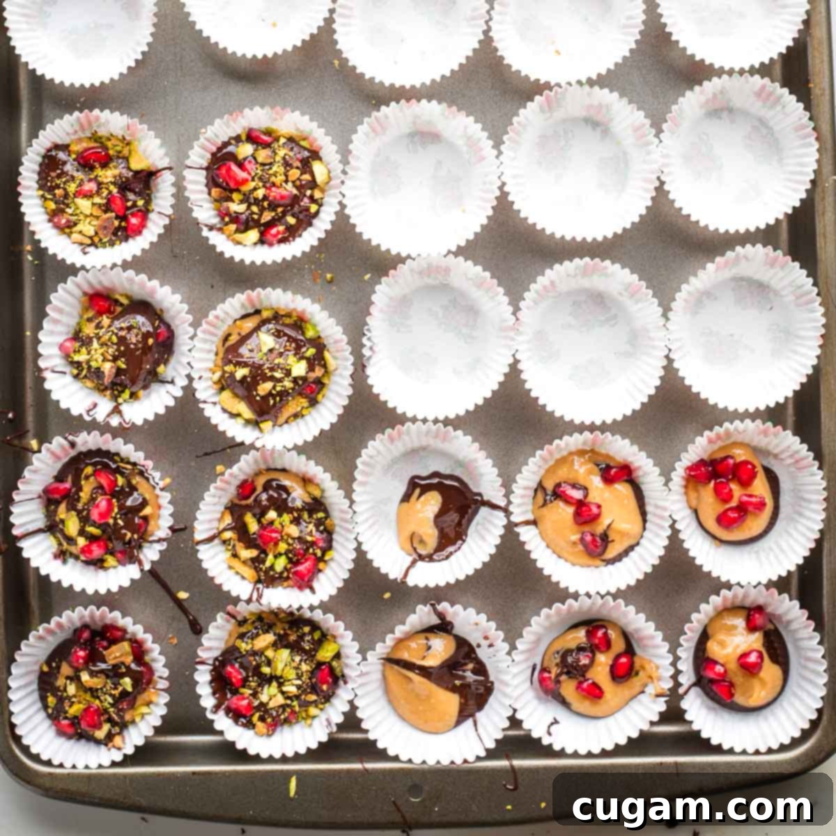 Mini cupcake liners filled with chocolate, peanut butter and chopped pistachios and pomegranate seeds. 