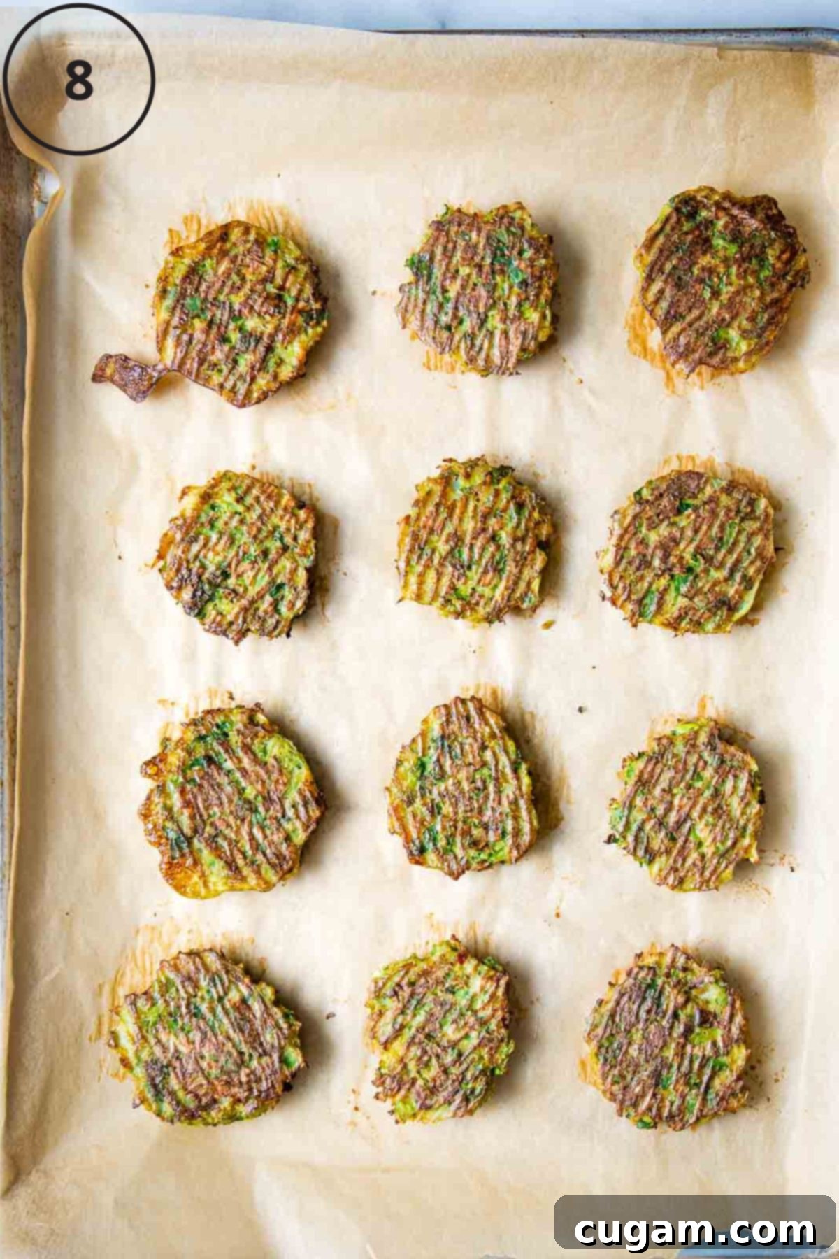 Crispy brussels sprouts latkes on a baking sheet lined with parchment.
