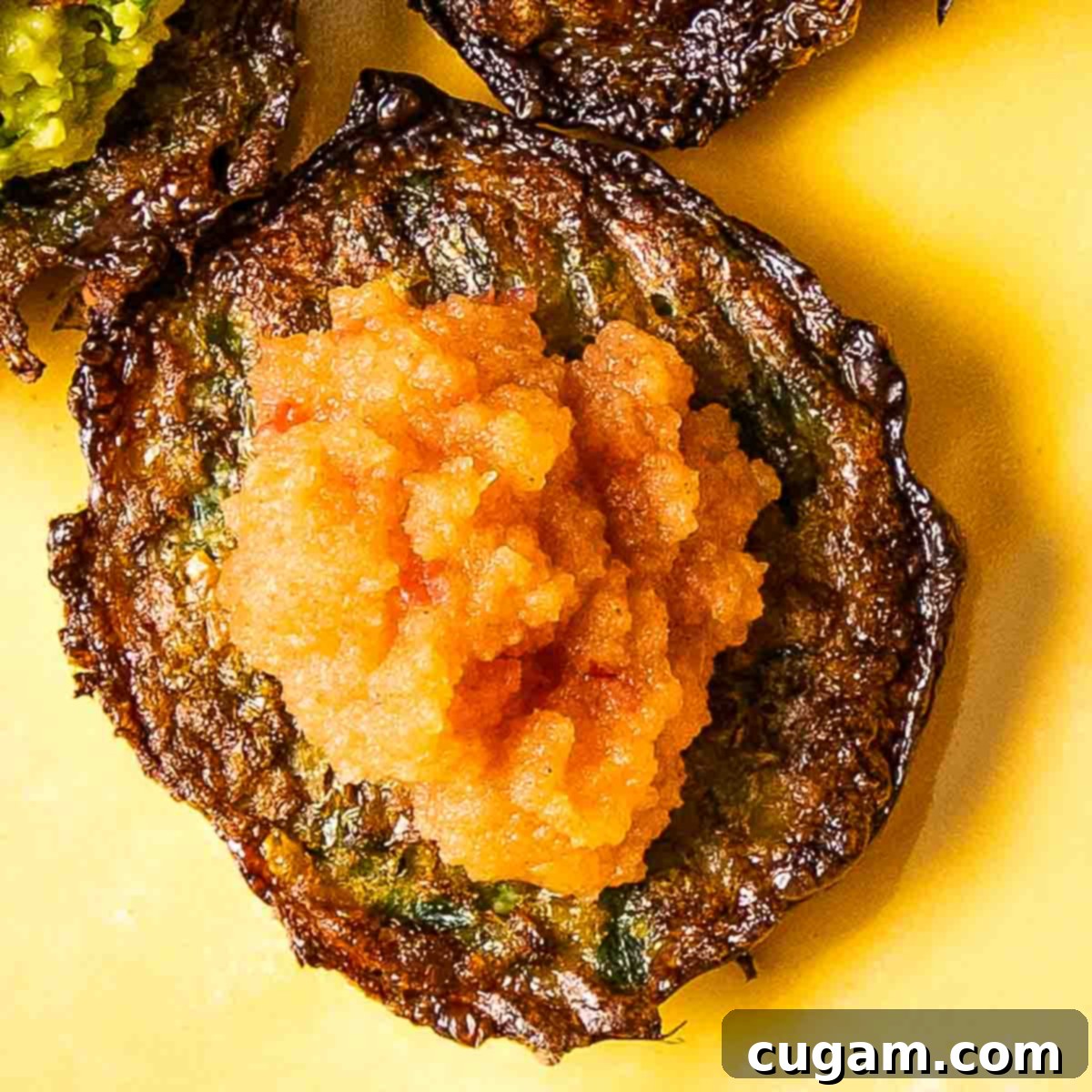 Crispy latke topped with pink applesauce.