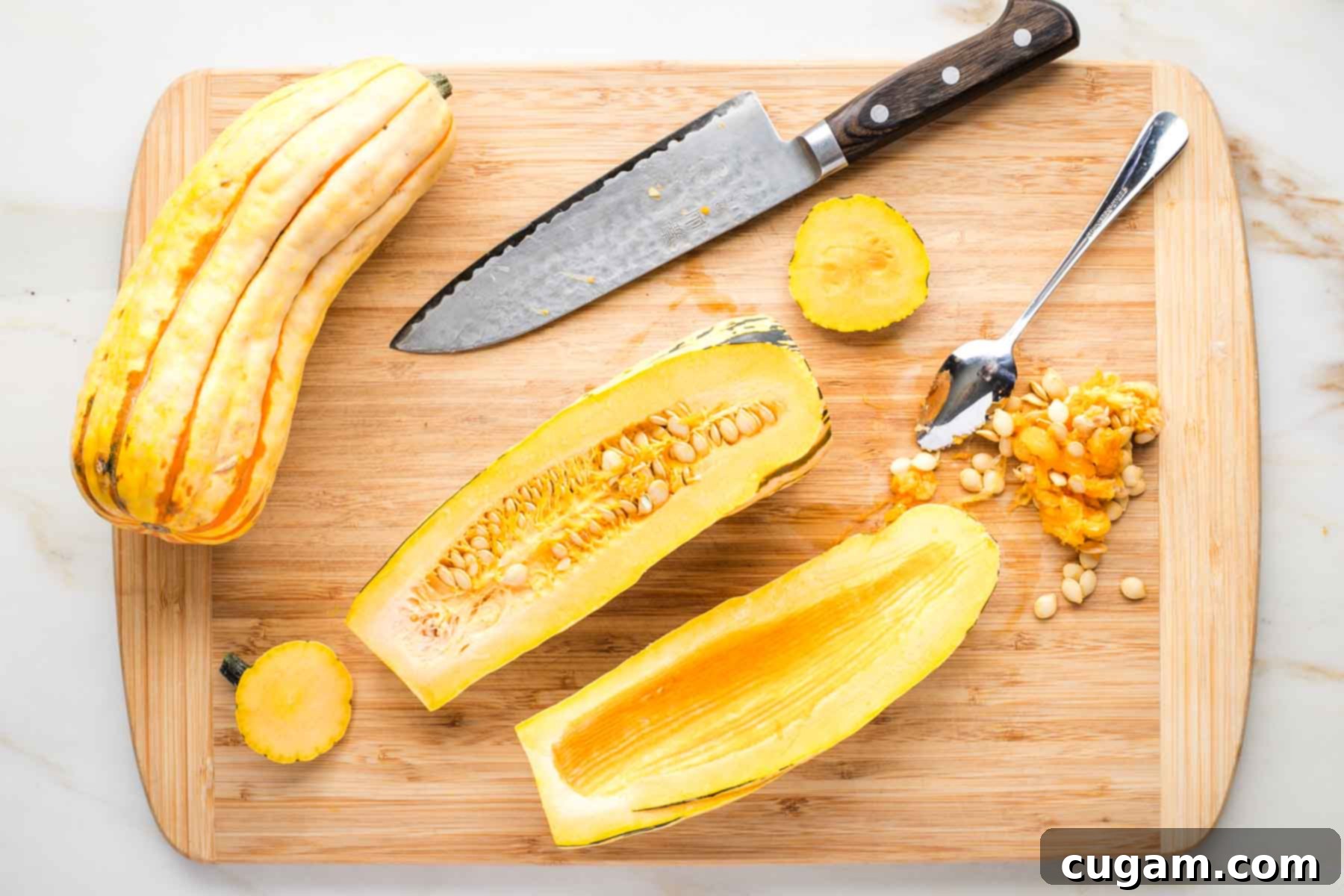 Delicata squash cut in half lengthwise with the seeds scooped out.