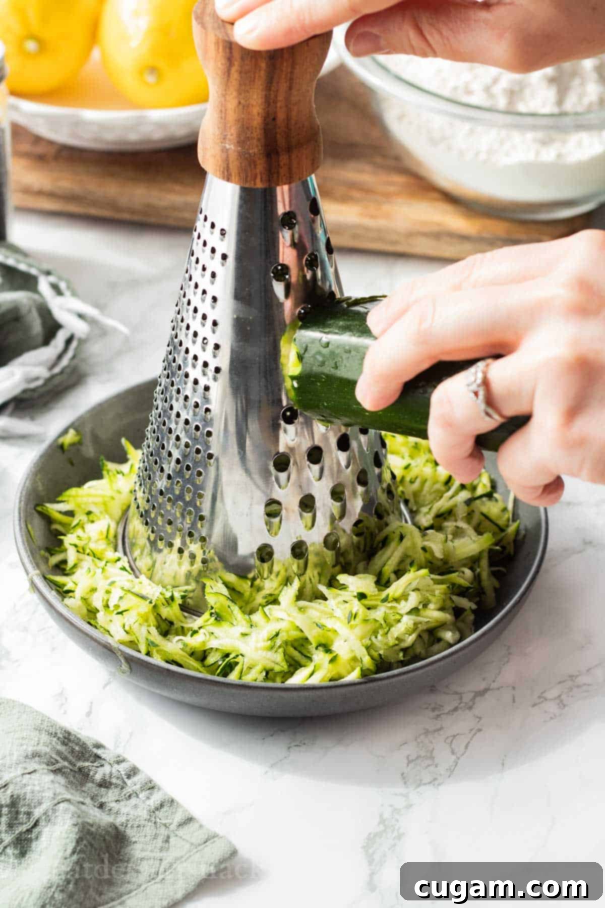 Hand grating zucchini into a plate.