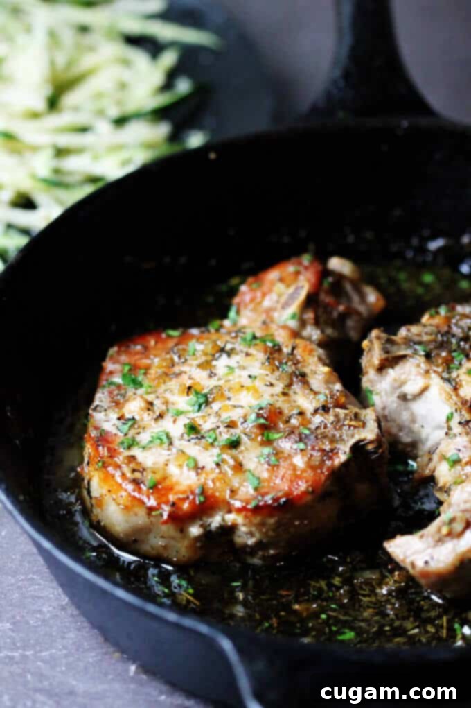 Brown sugar pork chops in a skillet with zucchini noodles on a plate