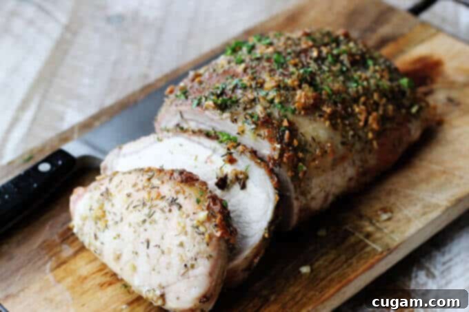 Brown sugar pork loin on cutting board with knife, horizontal shot.