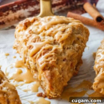 A beautifully baked maple caramel apple scone on parchment paper, ready to be enjoyed.