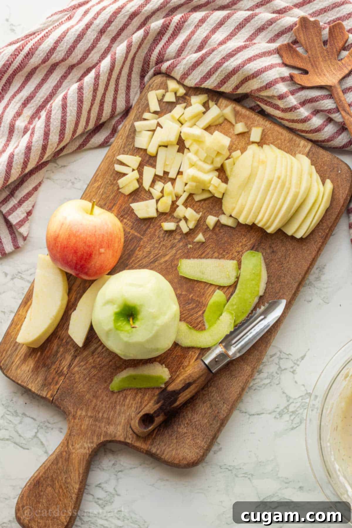 Apples at various stages of preparation: peeled, sliced, and finely chopped into small, uniform cubes on a wooden cutting board for apple cinnamon scones.