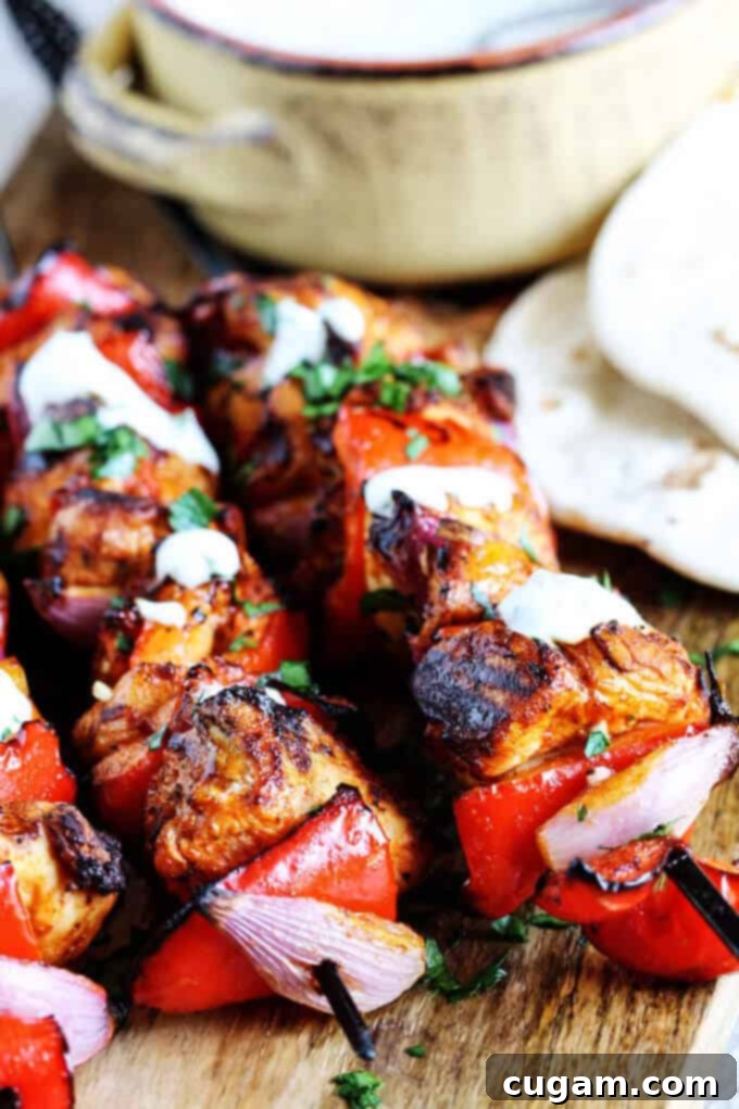 Raw chicken and vegetable cubes, including vibrant bell peppers and red onions, marinating in a flavorful Mediterranean spice blend, ready for skewering.