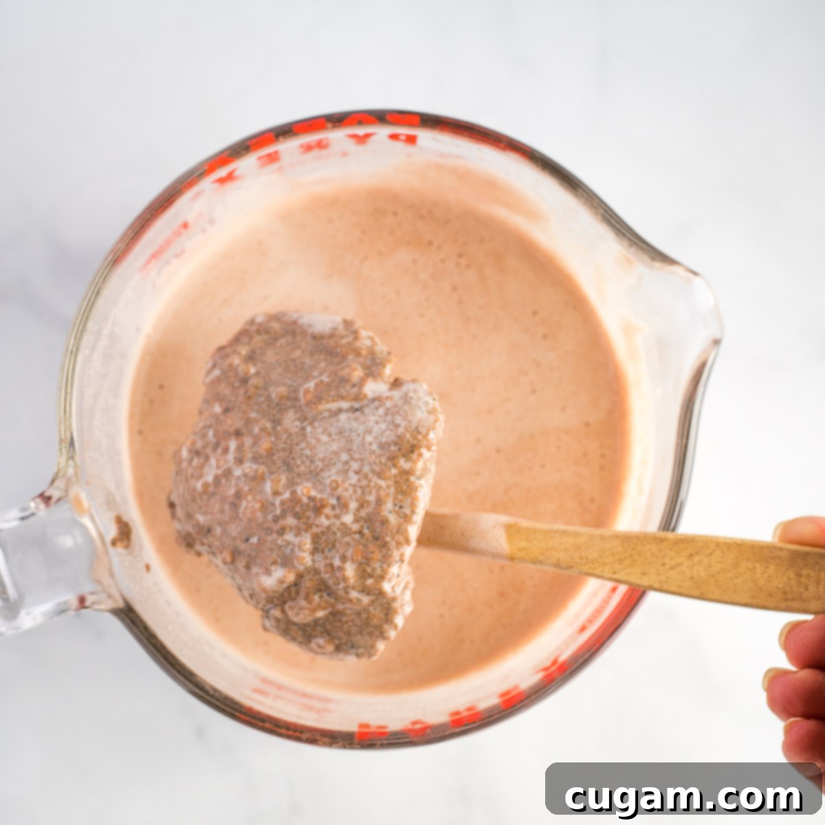 Large pyrex mixing cup with chocolate milk and a huge dry clump of chia seeds. 