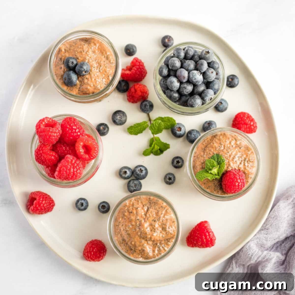 Small mason jars with chocolate chia pudding. Some with fresh berries too.