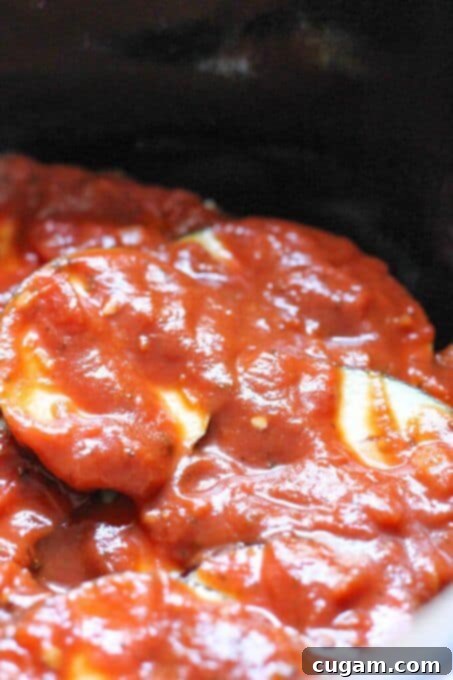 Marinara sauce poured over eggplant layer