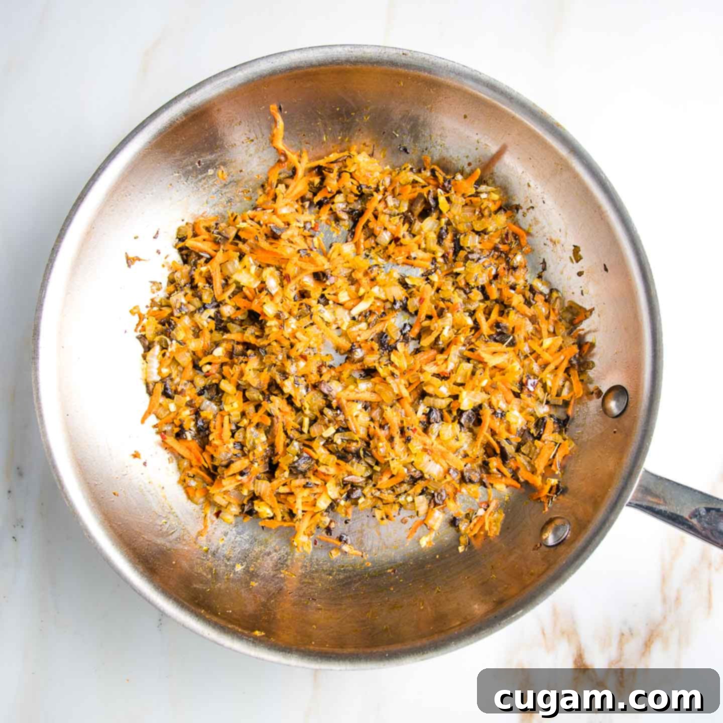 Sauteed mushrooms, onions and shredded carrots in a large fry pan.