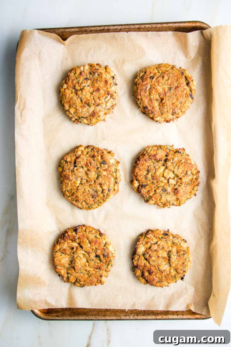 White bean veggie burger patties on a lined baking tray.
