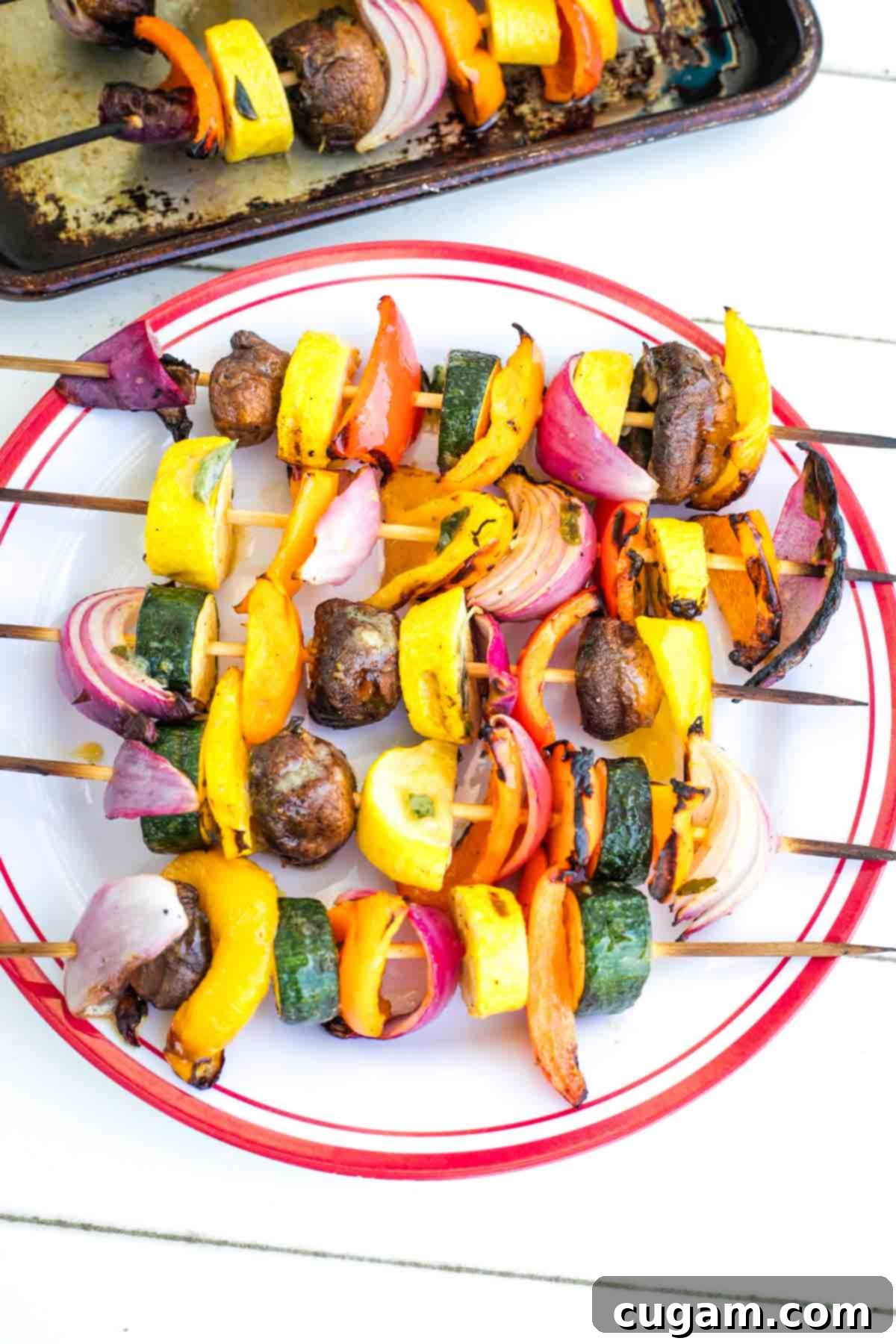 Mediterranean Harvest Skewers 2 Skewers of colorful vegetables that have been grilled.