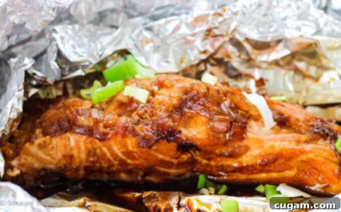 Final plated grilled salmon with homemade teriyaki sauce, garnished with green onions and fresh lime.